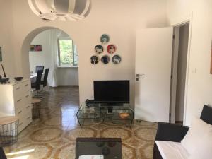 ein Wohnzimmer mit einem TV und einem Glastisch in der Unterkunft Villa Rosa Marina in Rosa Marina