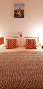 1 dormitorio con 1 cama con almohadas rojas en Villa Jade Apartments FRONT ROW SEA VIEW - WALK TO KORCULA OLD TOWN en Korčula