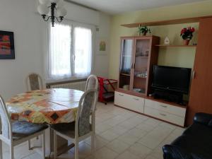 un soggiorno con tavolo e TV di Giardino a Porto Valtravaglia