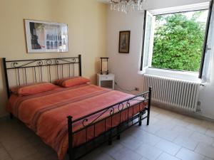 una camera con un letto e una grande finestra di Giardino a Porto Valtravaglia