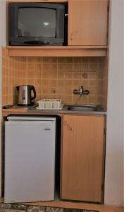 una pequeña cocina con microondas y nevera. en Family Rooms, en Ulcinj