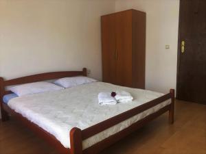 a bedroom with a bed with towels and a cabinet at Family Rooms in Ulcinj