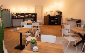 a restaurant with wooden tables and white chairs at Hotel Merian in Friedrichshafen