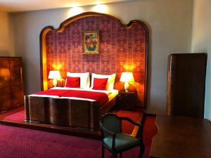 a bedroom with a large bed with a red headboard at Hotel Continental in Plzeň