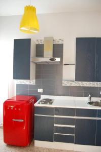 a kitchen with a red refrigerator and a sink at La Locomotiva in Chiaravalle
