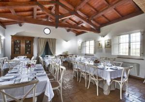 a room with white tables and chairs and a clock at Antico Casale Spezia Pelagalli in Aquino