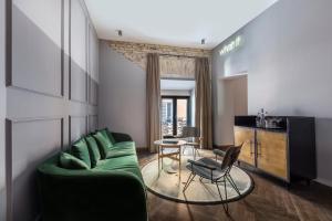 a living room with a green couch and a table at Chapter Roma in Rome