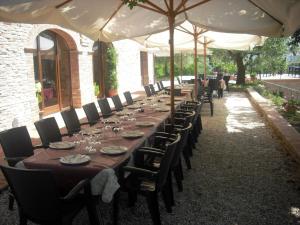 a long long table with chairs and umbrellas at Agriturismo Biologico Villa Rosa in Monte Guiduccio