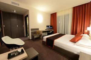 ティミショアラにあるHotel Galaxyのベッドとデスクが備わるホテルルームです。