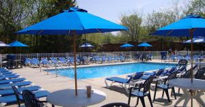 a pool with tables and chairs and blue umbrellas at Island Club #77 in Put-in-Bay