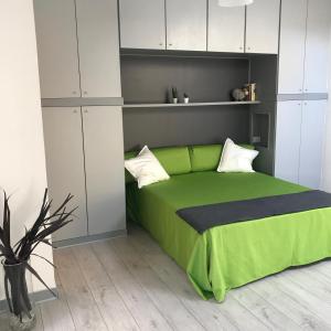 a bedroom with a green bed and white cabinets at Angel in Trieste