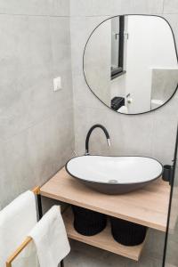 a bathroom with a sink and a mirror at Explore the City from Its Center in a Chic Balcony Apartment in Bucharest