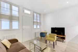 a living room with a couch and a table at Pick A Flat's Apartment in Batignolles - Passage Cardinet in Paris