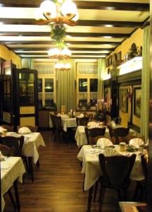 a restaurant with white tables and chairs and a chandelier at Hotel Alt Wassenberg in Wassenberg