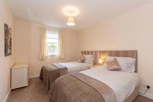 
a bedroom with a bed and a lamp in it at Central St Andrews 2 Bed Apartment - Free Parking in St. Andrews
