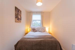 
a bedroom with a bed and a window at Central St Andrews 2 Bed Apartment - Free Parking in St. Andrews
