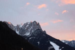 a view of a mountain range with a sunset at Hotel Vajolet in Mazzin