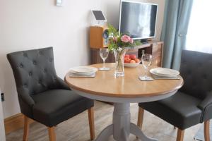 mesa de comedor con 2 sillas y mesa con copas de vino en Welch House, en Douglas