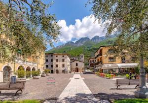 a city street with benches and mountains in the background at Garden Beth's House in Brenzone sul Garda