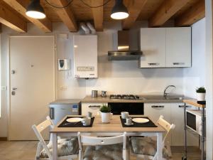 a kitchen with a wooden table with chairs and a stove at Interno 1 in Treviso