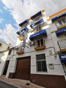 een wit gebouw met een bord aan de zijkant bij Hotel Doña Carmen in Ronda