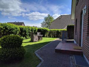 a patio with a table and chairs in a yard at Entspannt Wohnen - vor den Toren Lübecks in Stockelsdorf
