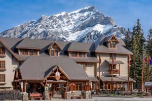 un grand bâtiment avec une montagne en arrière-plan dans l'établissement Banff Caribou Lodge and Spa, à Banff