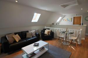 a living room with a couch and a table at Little Wisteria - Countryside views, Parking and Superking Bed in Canterbury