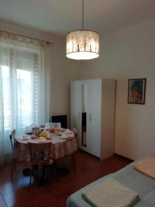 una sala da pranzo con tavolo e lampadario pendente di Le Comari a Milano