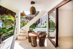 a room with a table and chairs in a house at The Beach Tulum Hotel in Tulum