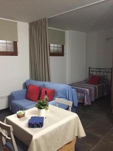 sala de estar con sofá azul y cama en Apartamentos Hautacuperche, en San Sebastián de la Gomera