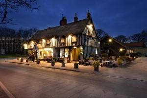 un edificio antiguo con luces en una calle por la noche en The Bell Inn, en Newmarket