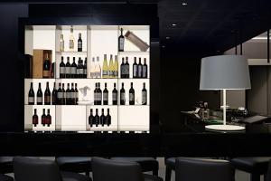 uma exposição de garrafas de vinho numa parede em Link124 Hotel em Parma