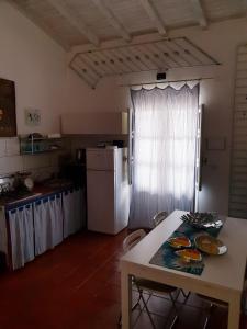 シラクーサにあるIl Nido di Diana in Ortigiaのキッチン(テーブル、白い冷蔵庫付)