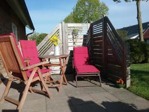 3 Stühle und ein Tisch auf einer Terrasse in der Unterkunft Ferienwohnung Paula, Kluis in Gagern