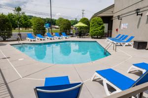 a patio area with chairs, tables, and umbrellas at Twin Mountain Inn & Suites in Pigeon Forge