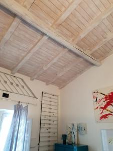シラクーサにあるIl Nido di Diana in Ortigiaの木製の天井と窓が備わる客室です。