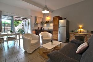 un soggiorno con divano e sedie e una cucina di TropikAppart a Les Avirons