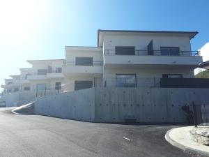 a white building with a fence in front of it at charmant studio dans résidence neuve et calme in Corte