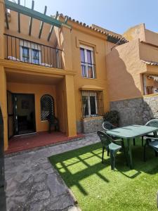 a patio with a table and chairs in front of a house at Casa adosada con jardín in Tarifa