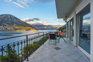 a balcony with a view of the water and mountains at Villa KOSTA in Donji Morinj