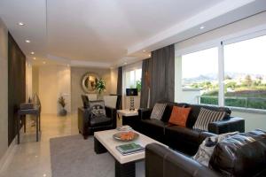 ein Wohnzimmer mit Couch und Tisch in der Unterkunft Apt 322 Heaven Beach Apartments, Guadalmansa Playa in Estepona
