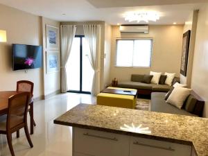 Una gran sala de estar con un sofá y una mesa. en 500Mbps Wi-Fi 2 Largest 2 BDRM Condo in Grand Residences, en Cebú