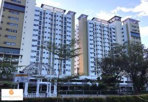 Un gran edificio blanco con árboles delante. en 500Mbps Wi-Fi 2 Largest 2 BDRM Condo in Grand Residences, en Cebú