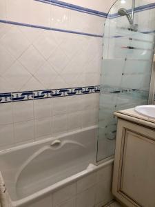 a bathroom with a bath tub and a sink at Le Noisetier in Cavalaire-sur-Mer