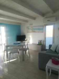 a living room with a table and a couch at Vista Mare tra i luoghi di Montalbano in Punta Secca
