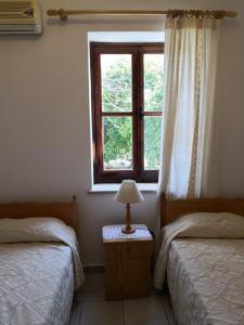 sypialnia z 2 łóżkami i oknem w obiekcie Spanos House w mieście Goudhi