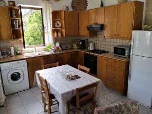 una cucina con tavolo e frigorifero bianco di Spanos House a Goudhi