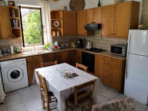 cocina con mesa y nevera blanca en Spanos House, en Goudhi