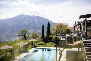 a villa with a swimming pool and a mountain at Hotel Patrizia in Tirolo
